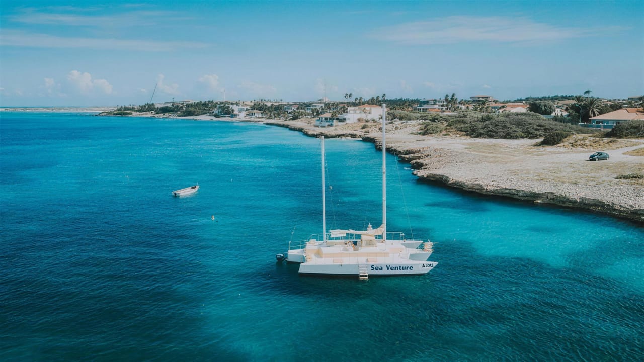 The Sea Venture at anchor in a turquoise bay along the north coast